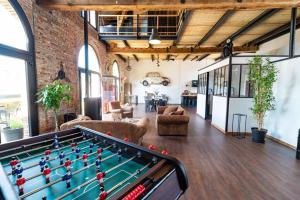 a living room with a pool table and a brick wall at Le Loft : Gîte avec spa à Marle in Marle-et-Behaine