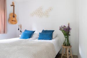 a bedroom with a bed with blue pillows and a guitar at Lodge Boomklever Nunspeet Veluwe in Nunspeet
