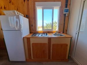 uma cozinha com um frigorífico branco e um lavatório em Tiny house camión fijo en Islas Canarias em Triquivijate