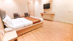 pokój hotelowy z łóżkiem i telewizorem z płaskim ekranem w obiekcie Hotel Yog Palace Newly Renovated 2023 w mieście Shirdi
