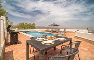 a patio with a table and chairs next to a pool at Beautiful Home In Iznate With Outdoor Swimming Pool in Iznate