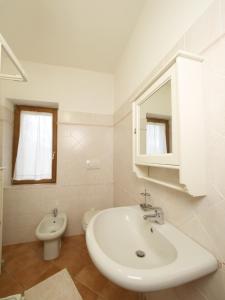 uma casa de banho branca com um lavatório e um WC em B&B ai Castagni em Bagnore