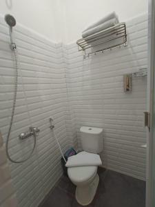 a bathroom with a toilet and a shower at Dawala Hotel in Sudiang