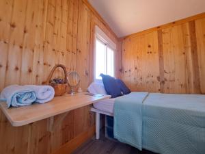 TriquivijateにあるTiny house camión fijo en Islas Canariasの木製の壁のベッドルーム1室、ベッド1台、窓が備わります。