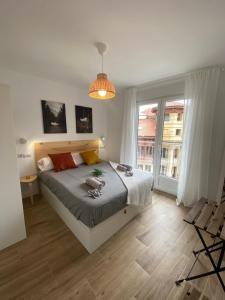 a bedroom with a bed and a large window at ETXIE LA CASA TARASKA in Bermeo