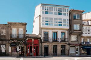 Coliving Compostela في سانتياغو دي كومبوستيلا: مبنى أبيض طويل على زاوية شارع