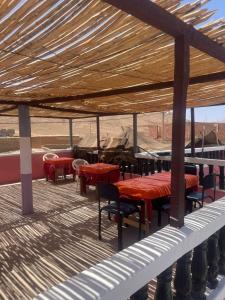 un groupe de tables et de chaises sur une terrasse dans l'établissement Riad Bouchra, à Tamtetoucht