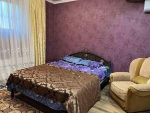 1 dormitorio con 1 cama y 1 silla en Комната с собственной ванной комнатой, en Chişinău