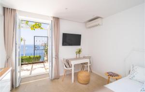 a bedroom with a bed and a table and a balcony at Beautiful Apartment In Dubrovnik With Jacuzzi in Dubrovnik