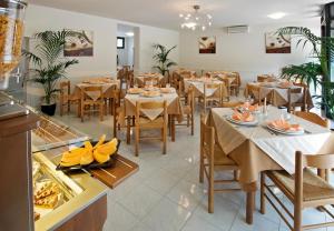 ein Restaurant mit Tischen und Stühlen in einem Zimmer in der Unterkunft Hotel Roma in Ravenna