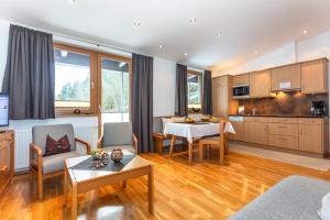 sala de estar con mesa y cocina en Apartment Landhaus Buchner, en Zell am See