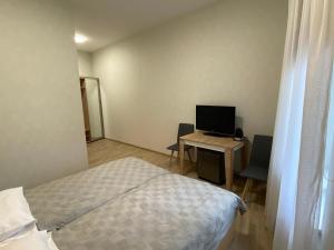 a bedroom with a bed and a desk with a computer at Neiroprakse Mini Hotel in Daugavpils