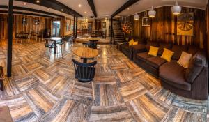 a lobby with a wooden floor with a couch and tables at Departamentos de turismo - Apart Hotel MiCasa in Futrono