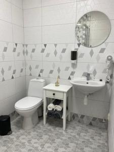 a bathroom with a toilet and a sink and a mirror at Neiroprakse Mini Hotel in Daugavpils