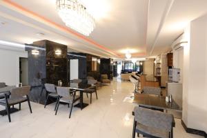 uma sala de jantar com mesas e cadeiras e um lustre em Mira Hotel Antalya em Antalya