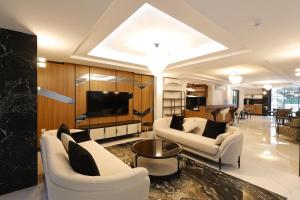 a living room with two white couches and a tv at Mira Hotel Antalya in Antalya