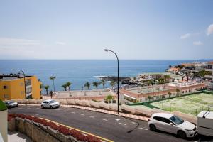 - une vue sur une rue avec des voitures garées sur la route dans l'établissement Ocean view apartment in front of Playa la Arena beach, à Puerto de Santiago