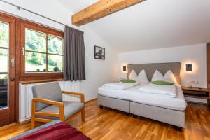 Habitación de hotel con cama y silla en Apartment Landhaus Buchner, en Zell am See
