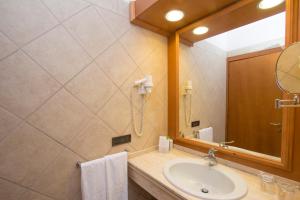 ein Bad mit einem Waschbecken und einem Spiegel in der Unterkunft Hotel Centrale in Sabaudia