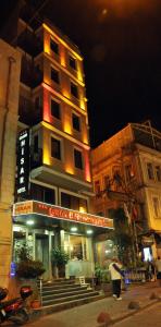 イスタンブールにあるグランド ヒサール ホテルの夜の建物前に立つ女