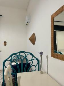 une table blanche avec une chaise bleue et un miroir dans l'établissement SALUTAMU, à Locogrande