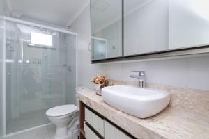 y baño con lavabo, aseo y ducha. en Aluguel Apartamento 2 quartos c/ 1 suíte | Bombas/SC, en Bombinhas