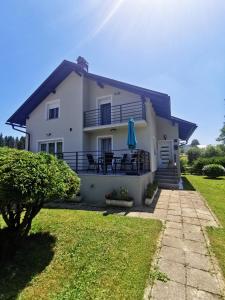 Jasenak的住宿－Kuća za odmor - Agatha - Bjelolasica，白色的房子,设有庭院和草坪