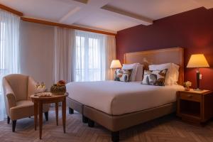 a hotel room with a large bed and a chair at Les Jardins Du Marais in Paris