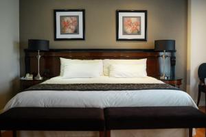 a bedroom with a large bed with two pictures on the wall at Amérian Executive Córdoba Hotel in Córdoba