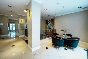 a hallway with a round table and blue chairs at Amérian Executive Córdoba Hotel in Córdoba