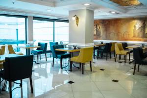 a dining room with tables and chairs and a wall of windows at Amérian Executive Córdoba Hotel in Córdoba