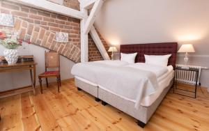 a bedroom with a large bed and a brick wall at Up Hus Hotel Neuruppin in Neuruppin