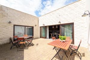 Un patio con una mesa y sillas de madera. en Rókusfalvy Birtok Vendégház Etyek, en Etyek 6 fotos más