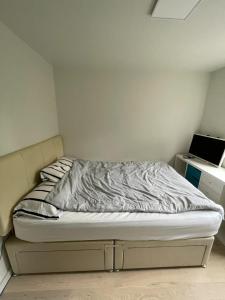 an unmade bed in a small room with a desk at Modern & Compact 1BD Flat - Caledonian Road in London
