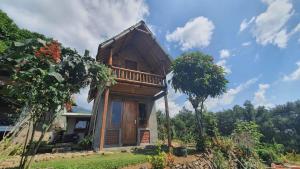 una pequeña casa de madera con un árbol delante en Villa Lumbung Salak en Bogor