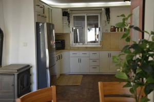 een keuken met witte kasten en een roestvrijstalen koelkast bij וילה פינתית עם נוף פאנורמי לכנרת in Nof Kinneret