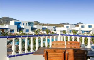 a balcony with two chairs and a table and buildings at Villas Del Mar in Puerto Calero