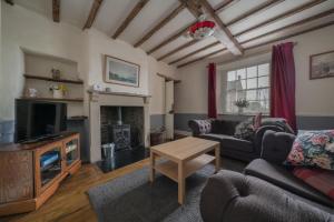 a living room with a couch and a tv at Bank House | Peak District in Longnor