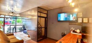 ein Wohnzimmer mit einem Flachbildfernseher an der Wand in der Unterkunft Jewel Tourist Inn in Coron