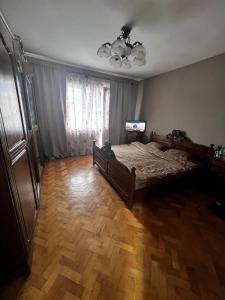 a bedroom with a bed and a wooden floor at Casa Maramureșanului in Sighetu Marmaţiei