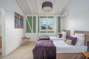una camera da letto con due letti e una finestra di Luxueuse Villa Katleya, vue mer a Le Vauclin