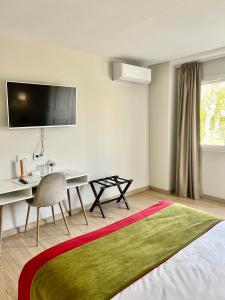 a bedroom with a desk and a bed and a table at La Maison TATIN in Lamotte-Beuvron