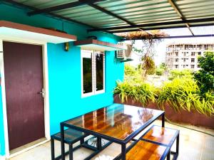 eine Terrasse mit einem Tisch und einer blauen Wand in der Unterkunft ASSHAPPYSTAYINN HOTEL in Tiruchchirāppalli