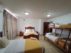 a bedroom with two bunk beds and a room with two beds at Hostal Bicentenario in Guayaquil