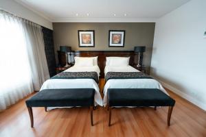 two beds in a hotel room with two seats at Amérian Executive Córdoba Hotel in Córdoba