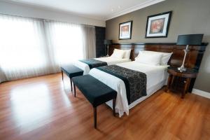a bedroom with two beds and a wooden floor at Amérian Executive Córdoba Hotel in Córdoba