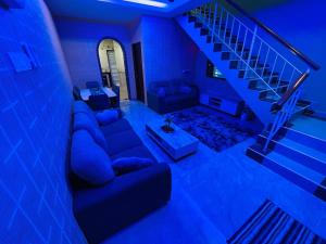 a blue room with a couch and a staircase at Cozy Kulai Retreat 5Min AeonPalm Resort15Min Senai airport in Kulai