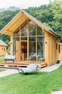 Cette grande maison en bois est dotée d'une grande fenêtre en verre. dans l'établissement Eco Lodges Millstätter See, à Döbriach