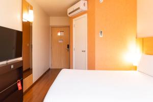 Un pat sau paturi într-o cameră la ibis Porto Alegre Moinhos de Vento