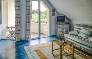 マティニョンにあるStunning Apartment In Matignon With House Sea Viewのリビングルーム(ベッド1台、テーブル付)、バルコニーが備わります。
